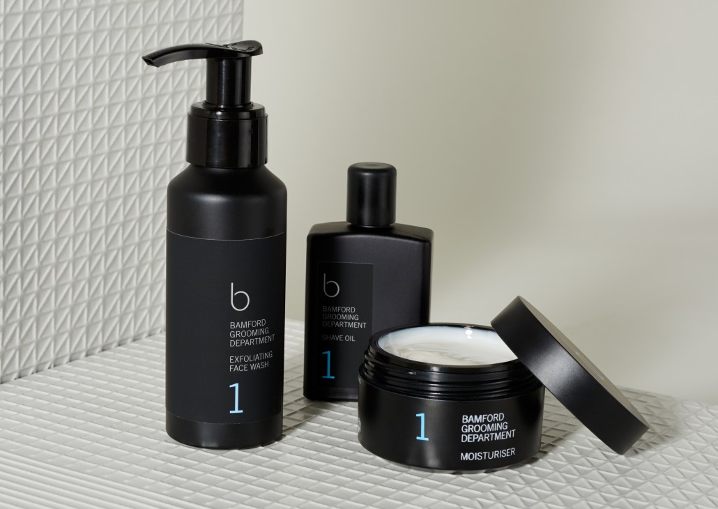 Three black Bamford Grooming Department products displayed on white textured tile background.