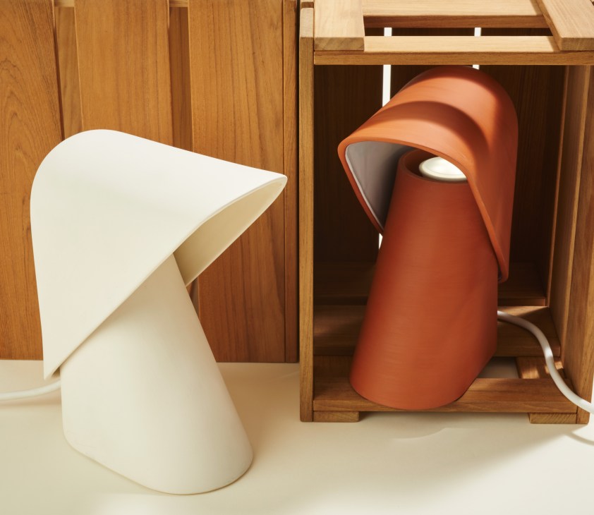 Vitamin K Lamp ceramic handmade light in white and terracotta displayed in wooden shelving.