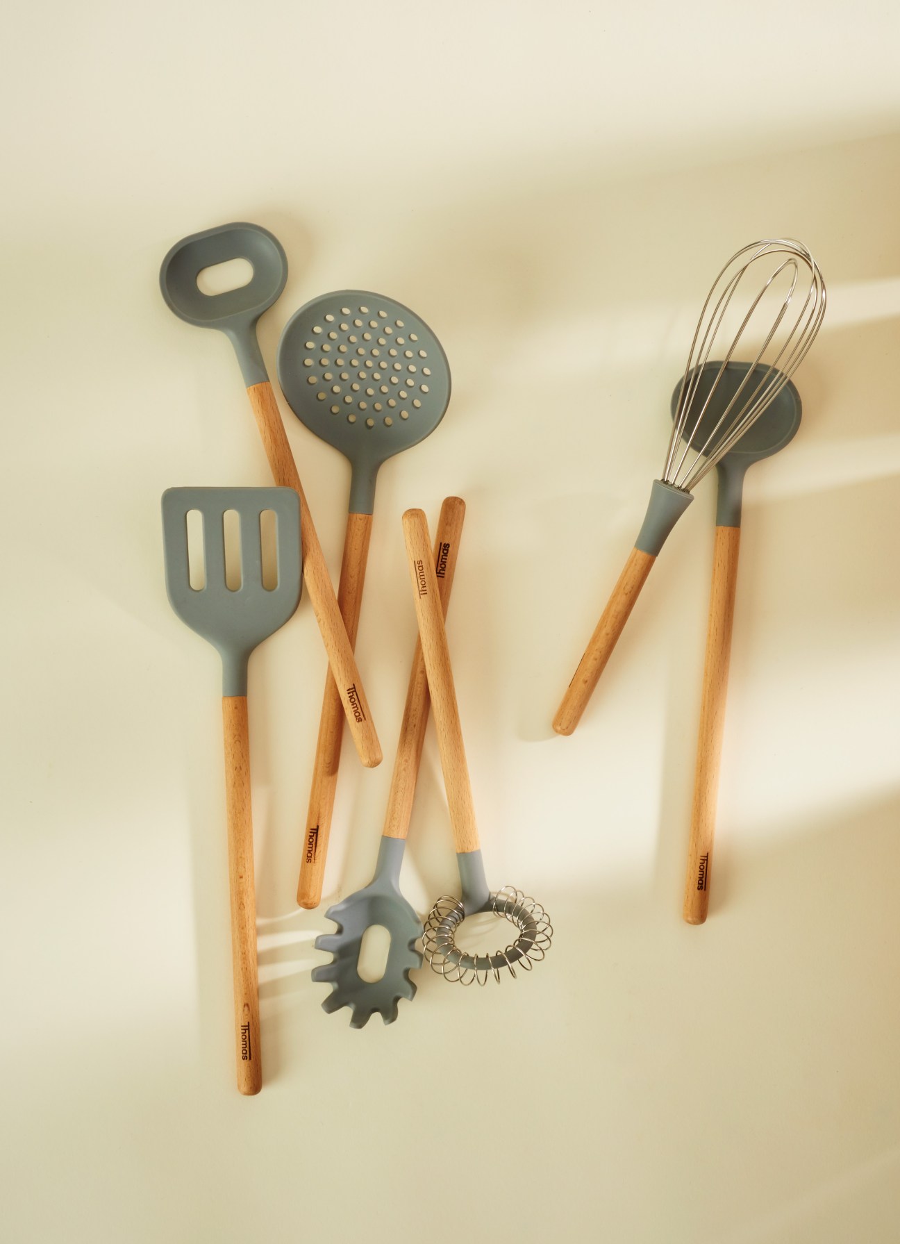 Kitchen utensils set with grey silicone heads and wooden handles by Office for Product Design.