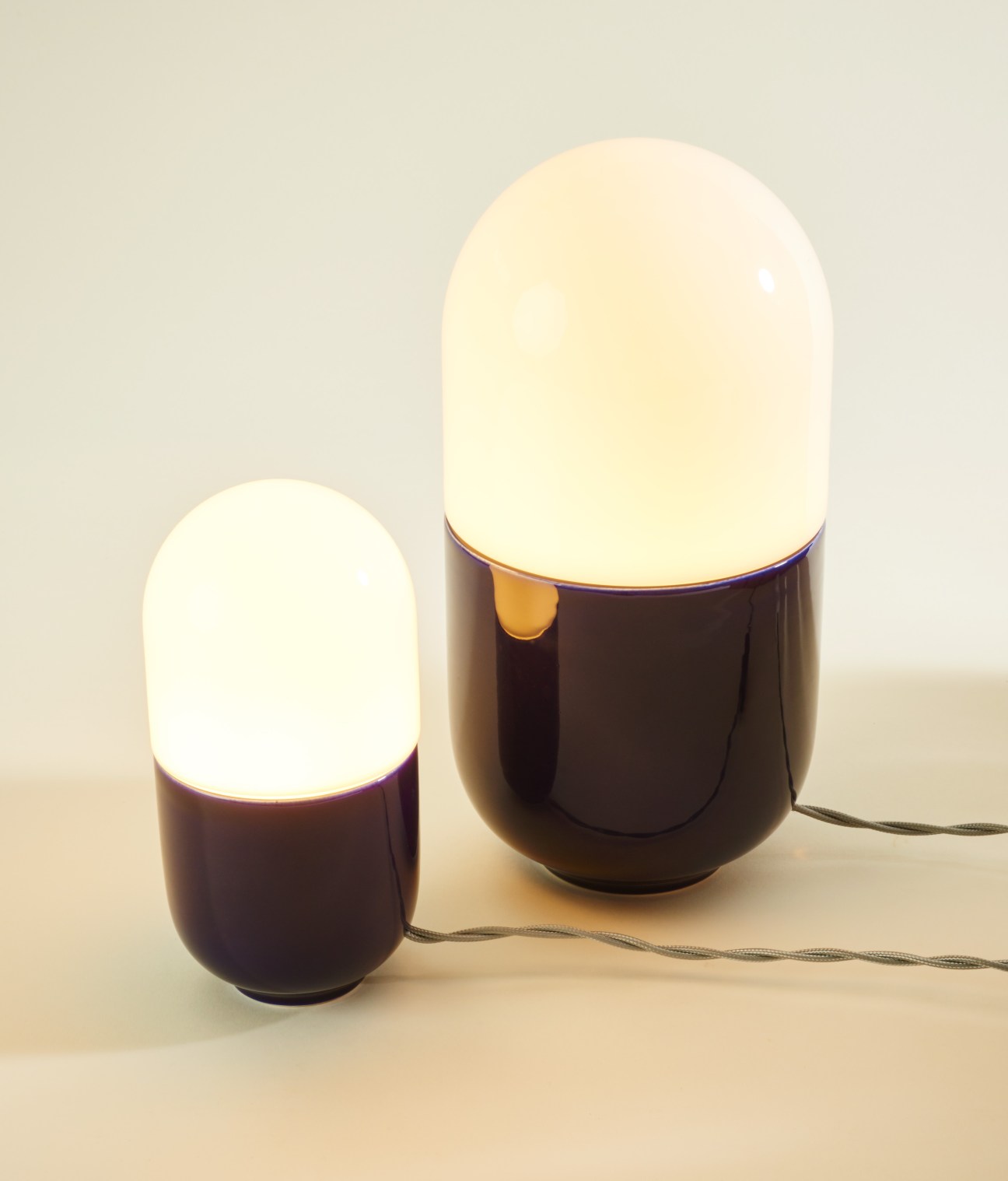 Two illuminated dome lamps with blue glass bases and frosted glass tops by Hand&Eye.