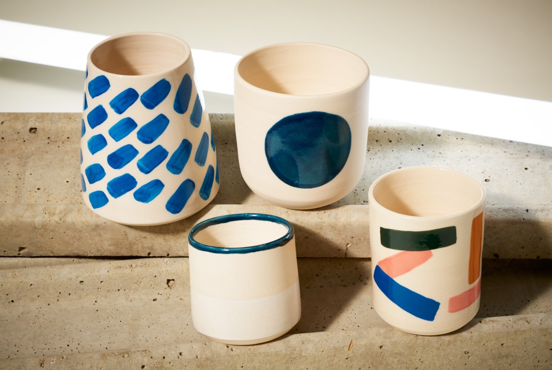 Five handmade ceramic cups and vessels by Weak End Club with blue, teal, and coral geometric patterns.