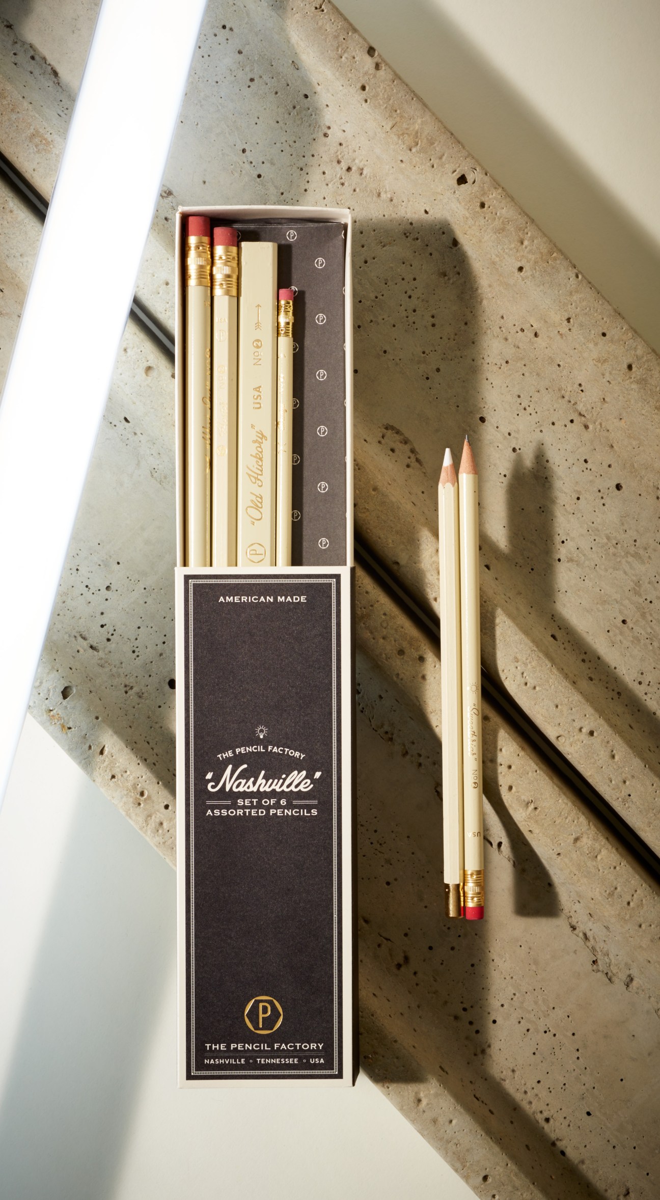 The Pencil Factory Nashville pencil set of six with gold foil-stamped details and red erasers on concrete surface.