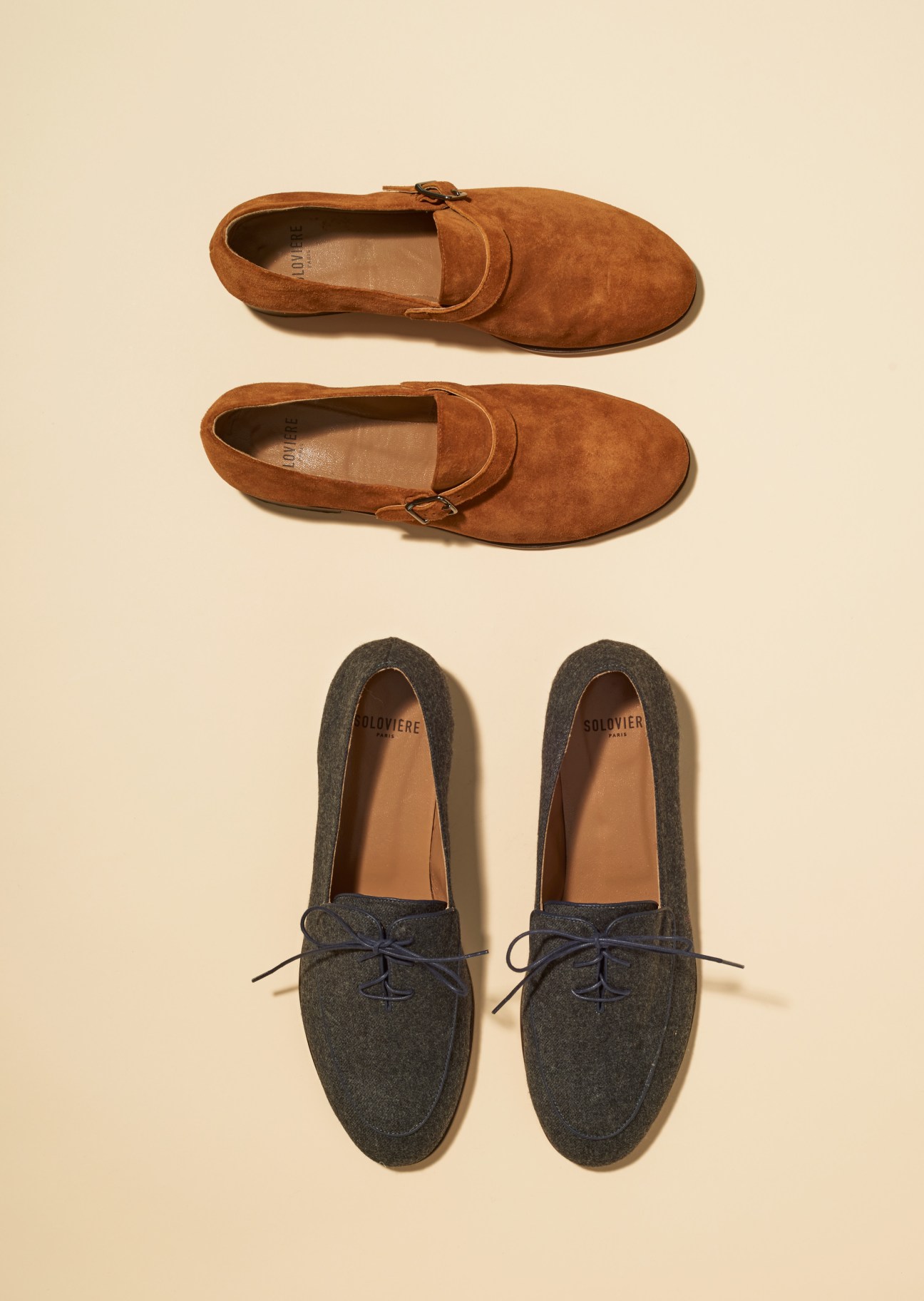 Two pairs of Solovière monk slippers displayed on a cream background—tan suede lace-ups above and charcoal wool loafers below.