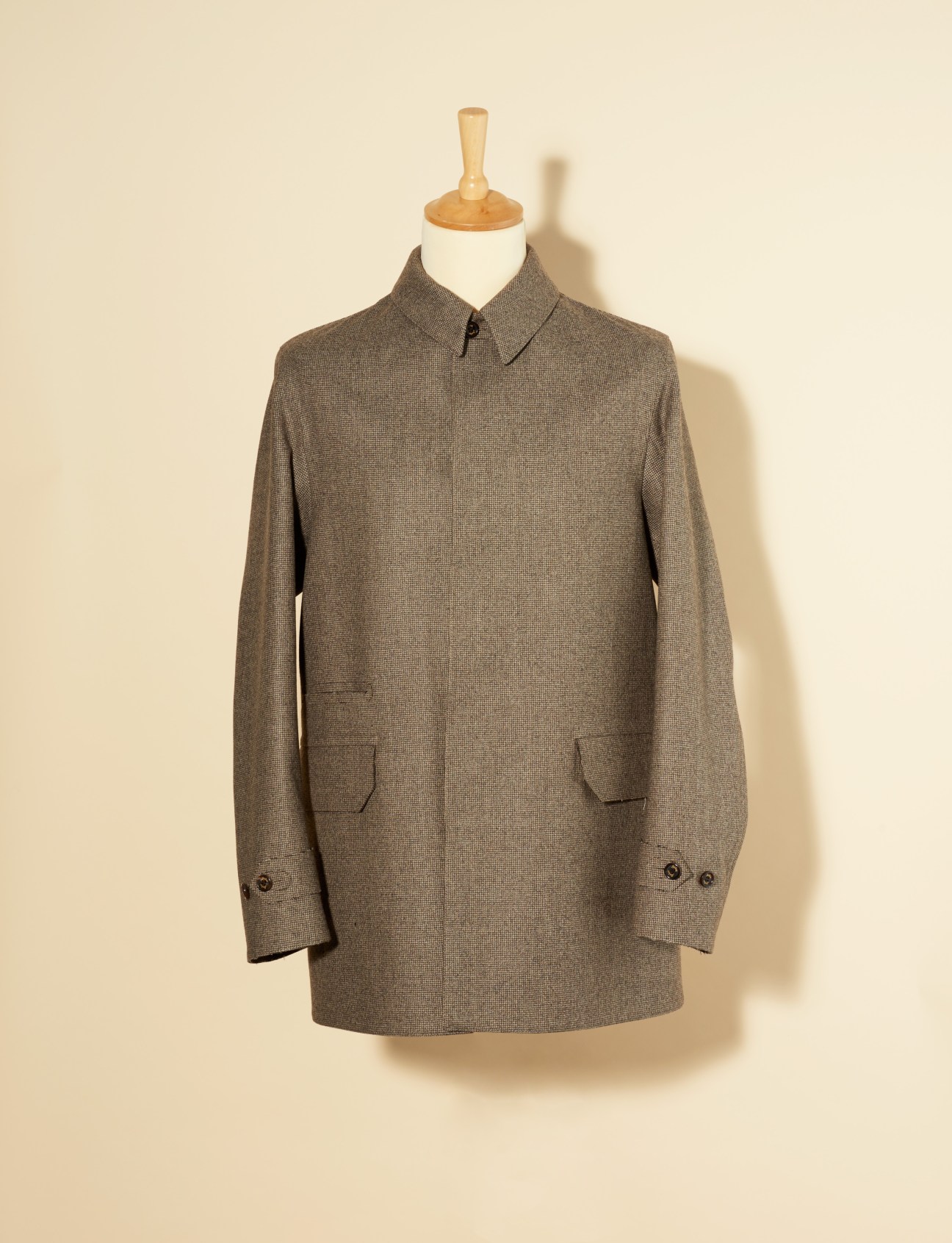 Gray wool bonded-flannel slim-fit jacket with collar and horn buttons displayed on a dress form.