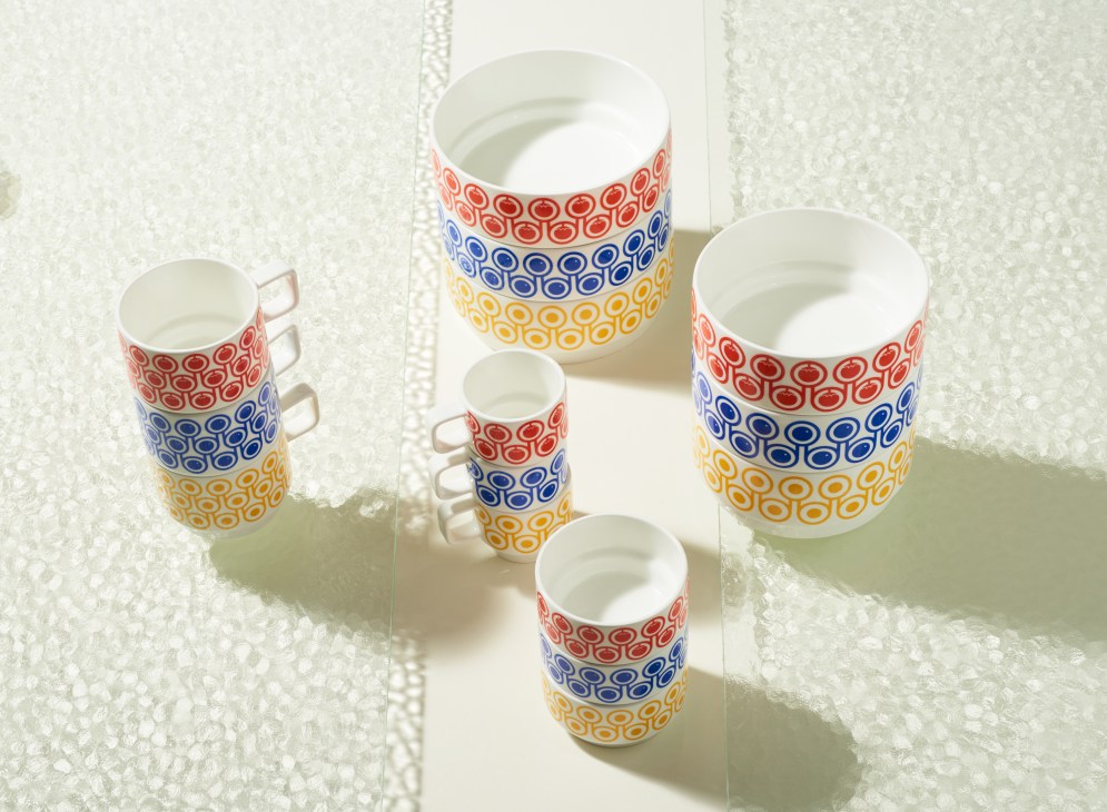 Hokolo ceramic cups and bowls with red, blue, and yellow circular patterns stacked on white surface.
