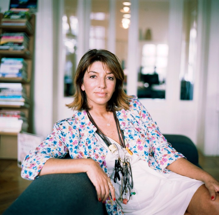 Ozlem Avcioglu, editor of TravelModus.com, poses in her office wearing a floral jacket.