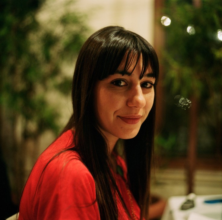 Pinar Birim, a graphic designer at FROG Studios Advertising Agency, smiles at the camera in a portrait.