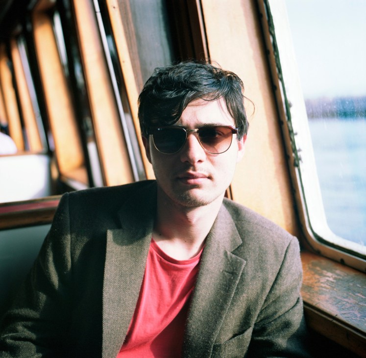 Luigi Mattiuci, owner of La Pesche, wearing sunglasses and a blazer on a boat with water visible through windows behind him.