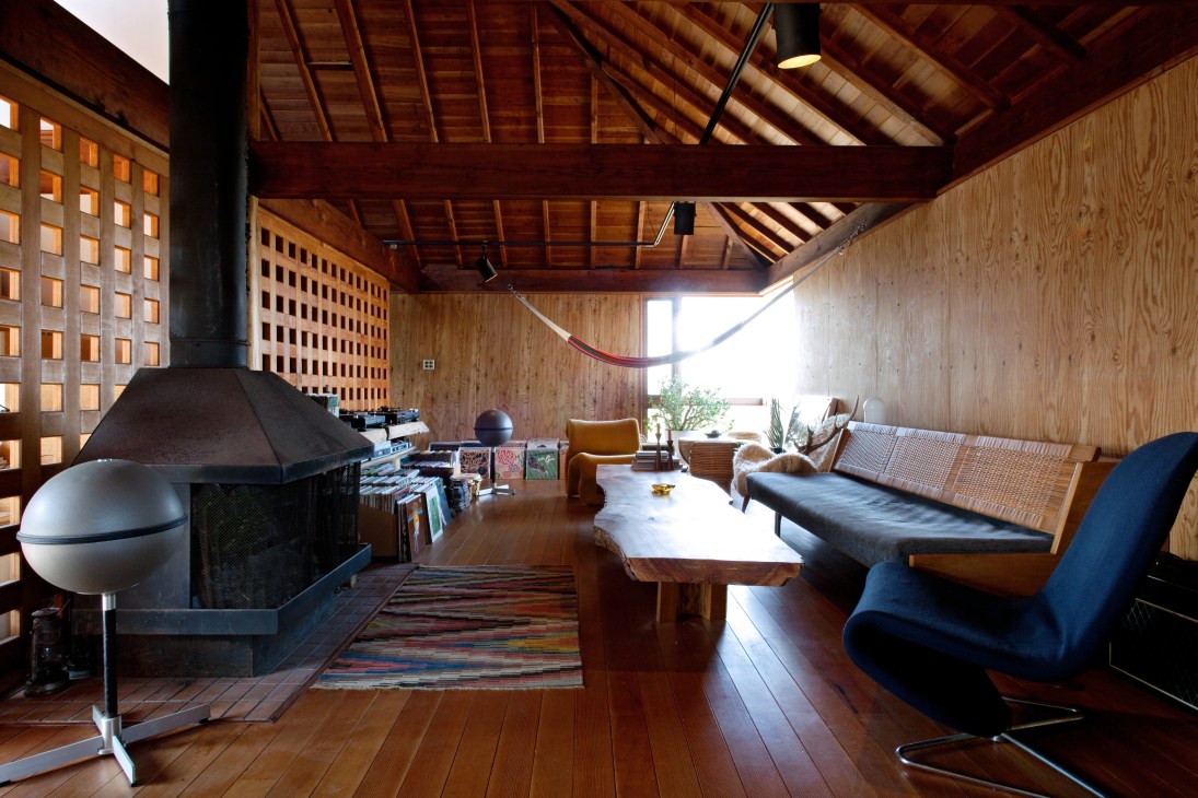 Wooden living room with vintage furniture, fireplace, and day bed by Hans Wegner.