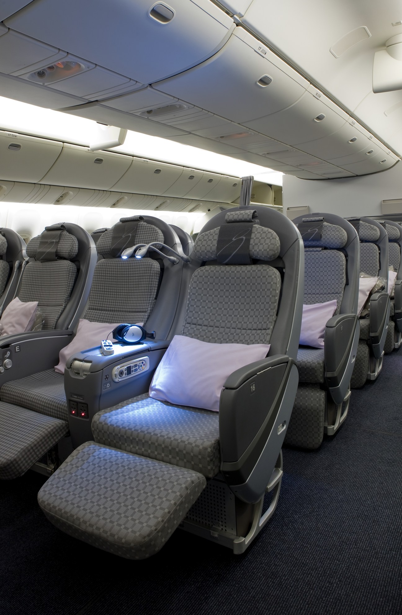JAL premium economy cabin with grey patterned seats and blue accent lighting