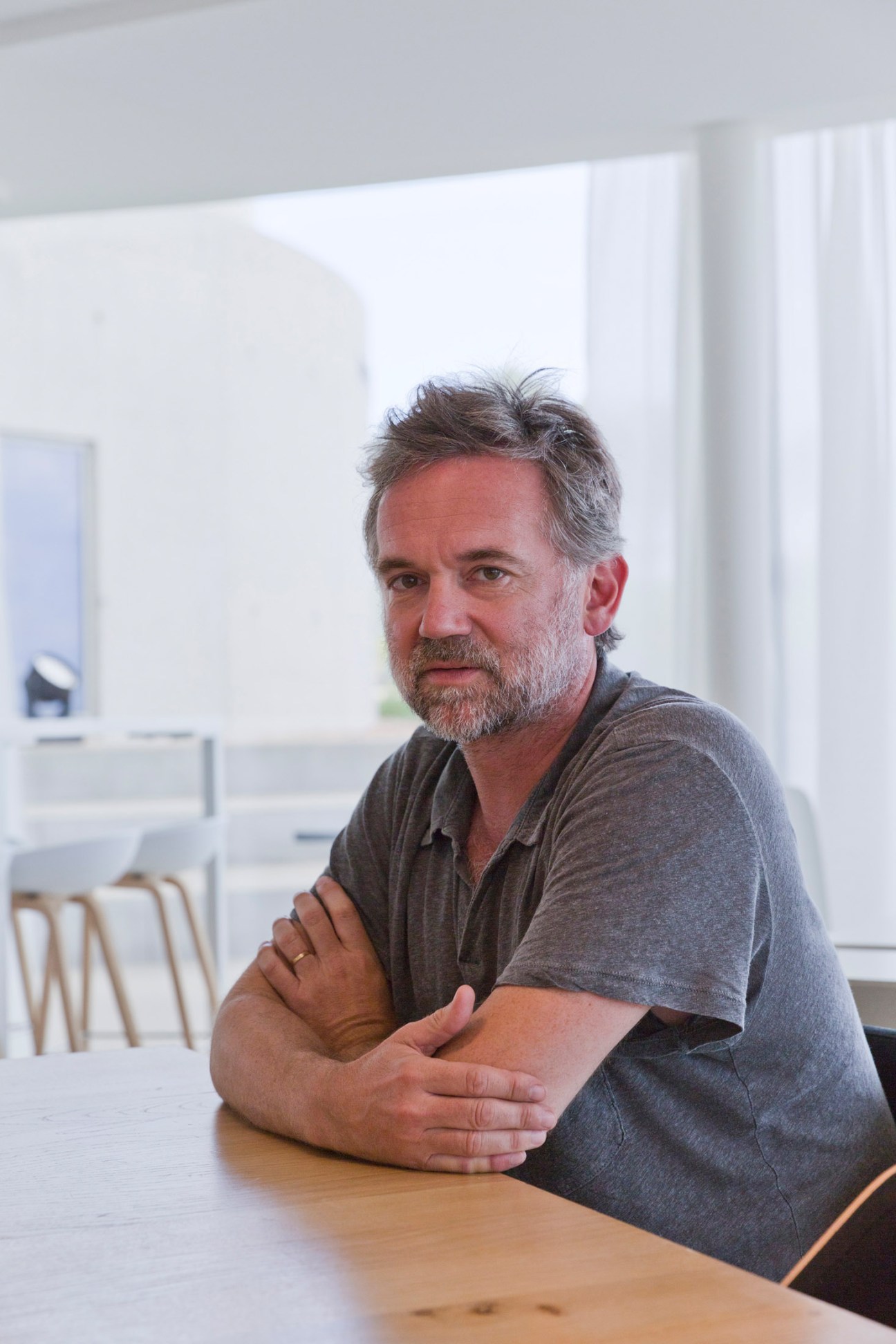 Olivier Mathiot, non-executive president of The Camp, sitting at a table in a bright modern interior space.