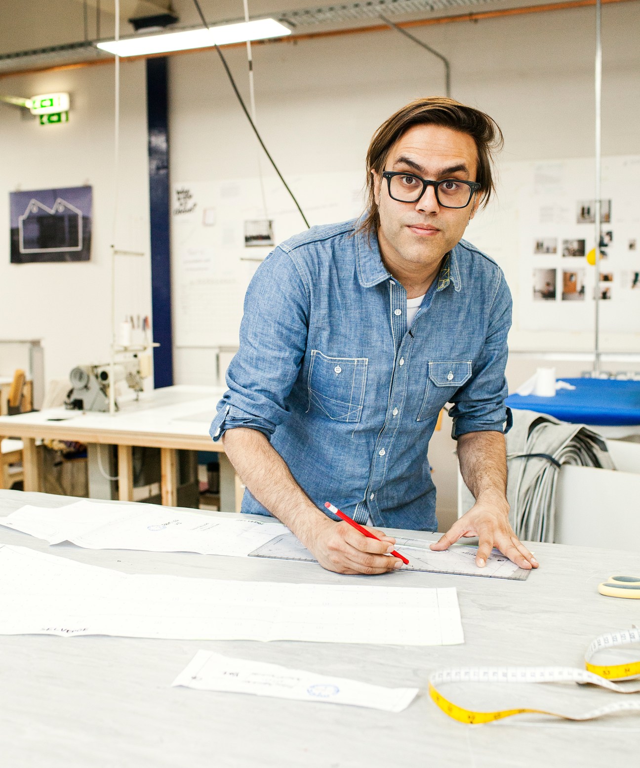 Creative consultant Mohsin Sajid at a table with design sketches in Blackhorse Lane Ateliers factory.