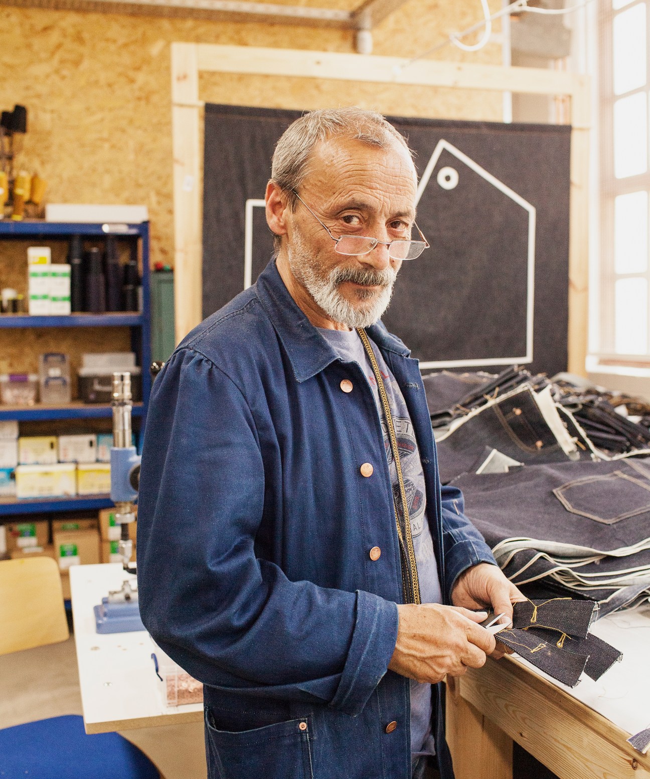 Kenan Habali, factory manager, holding denim fabric in the Blackhorse Lane Ateliers workshop.