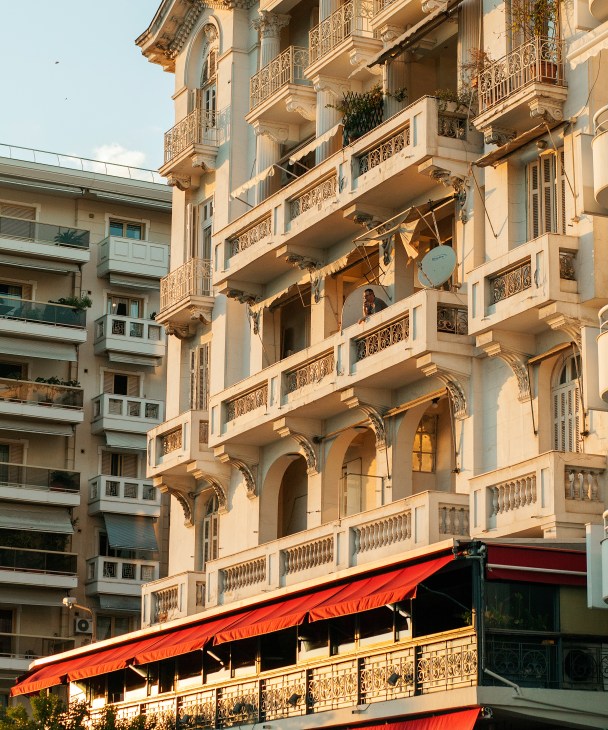 Ornate beige building facade with classical architectural details and balconies along Thessaloniki's seafront.