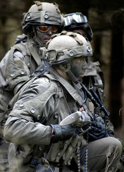 Austrian military conscripts in full combat gear with helmets and rifles.