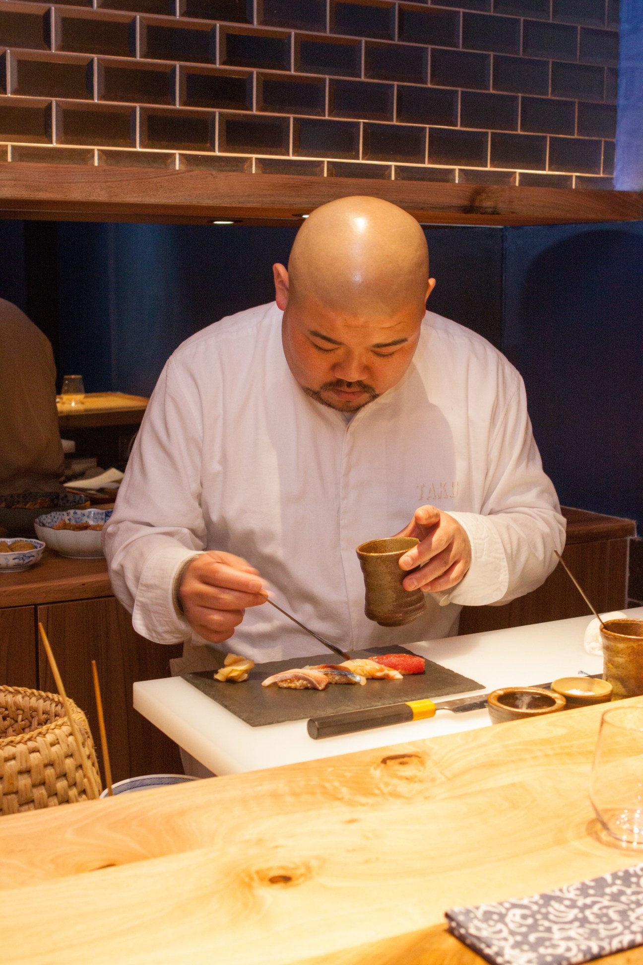 Chef Takuya Watanabe prepares sushi at the counter at Jin restaurant in Paris.