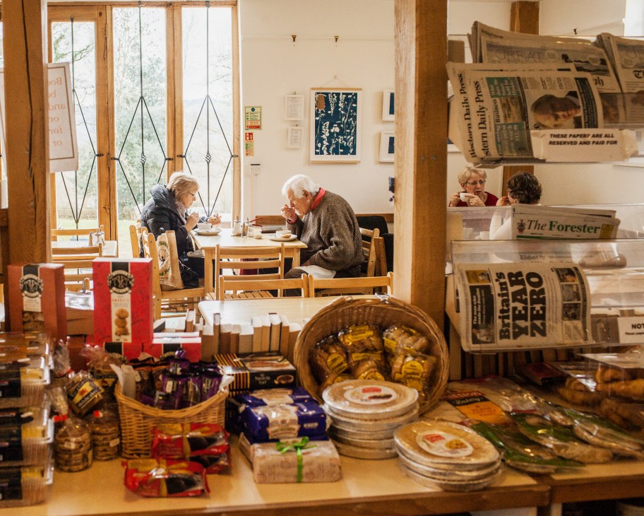 Customers enjoying lunch in the Brockweir and Hewelsfield Village Shop café, with local products displayed on the counter.