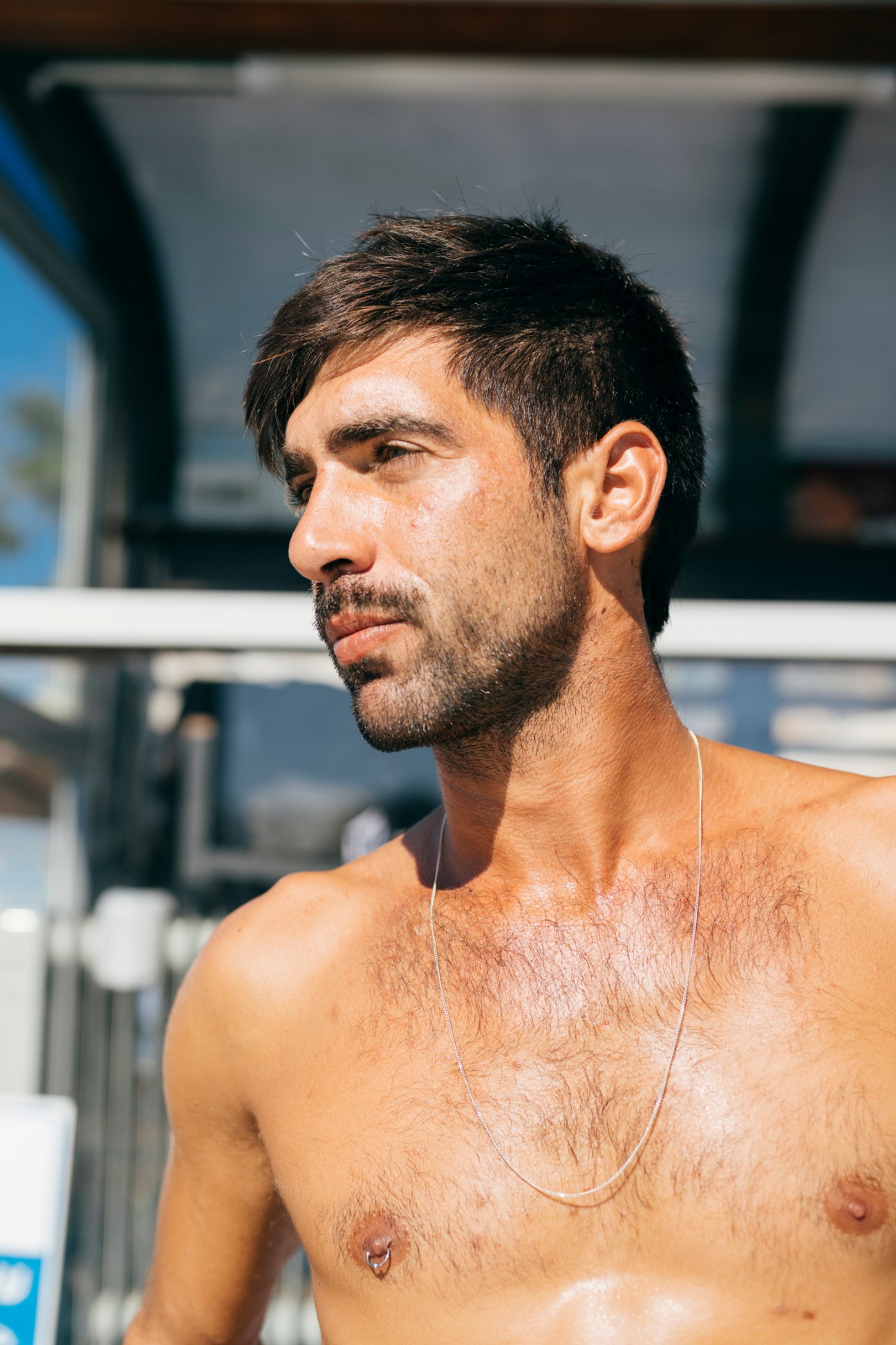 Shirtless lifeguard Ben Cohen looking to the side outdoors