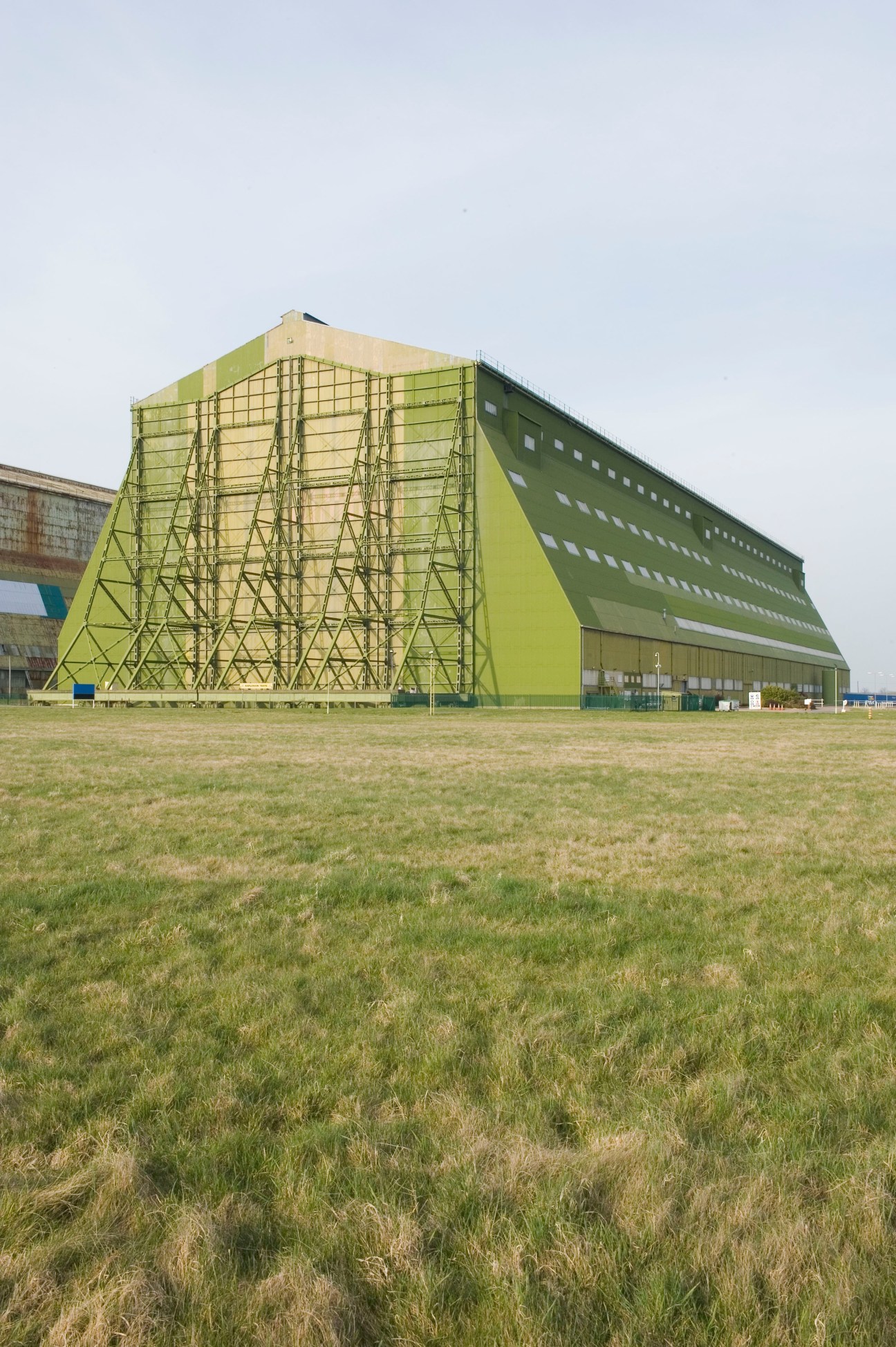 Hybrid Air Vehicles' base in a large green airship shed built during World War I, with scaffolding visible on the exterior.
