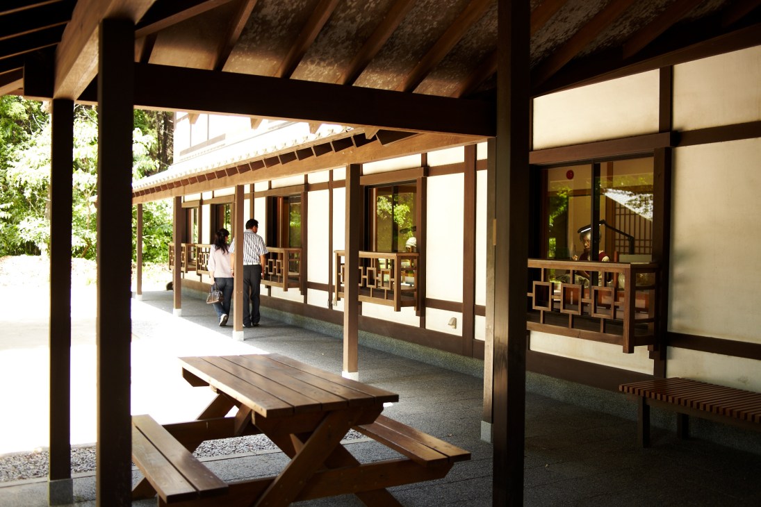 Traditional Japanese pottery workshop with wooden architecture and visitors walking through covered veranda at Chin Jukan in Miyama.
