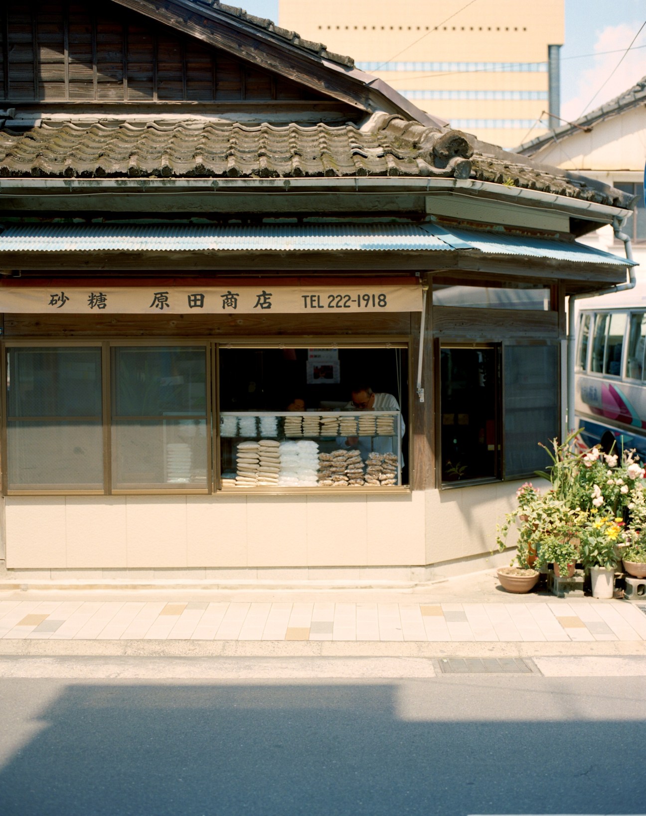 Harada Shoten sugar shop storefront with traditional Japanese architecture and stacked goods displayed in window.