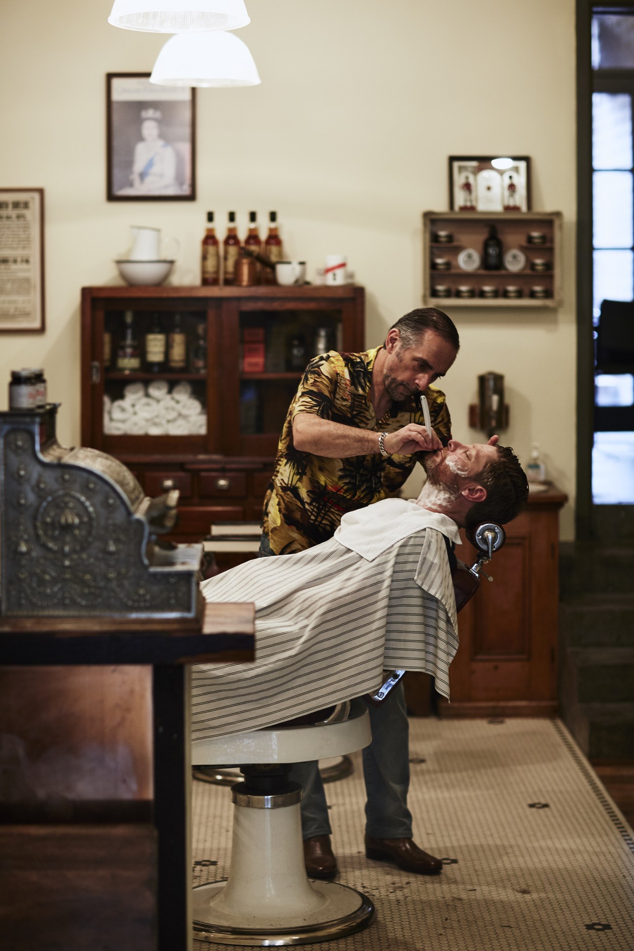 Christopher Pickings, owner and barber, cuts a customer's hair at Pickings and Parry barbershop.