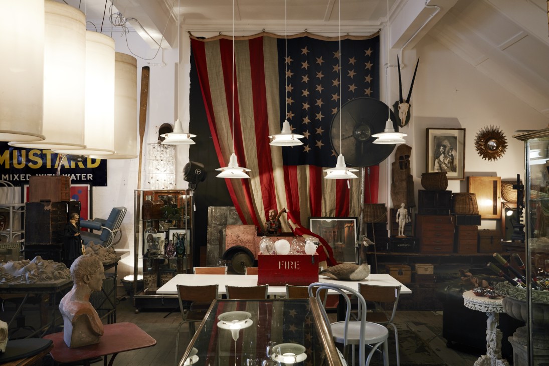 Interior of Tarlo & Graham antiques shop displaying vintage furniture, textiles, sculptures and decorative objects.
