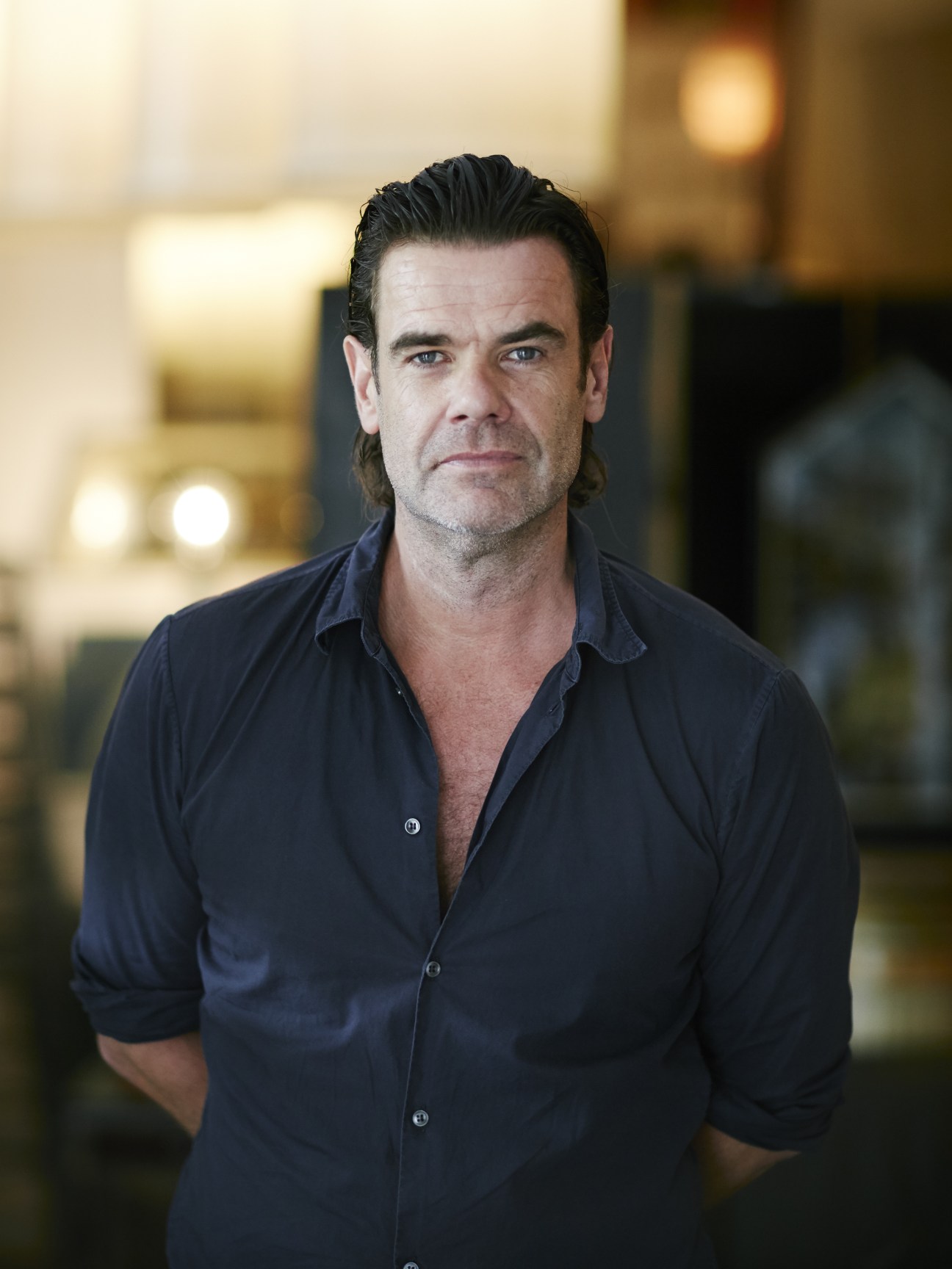 Antiques dealer Phillip Graham wearing a dark shirt poses for a portrait.