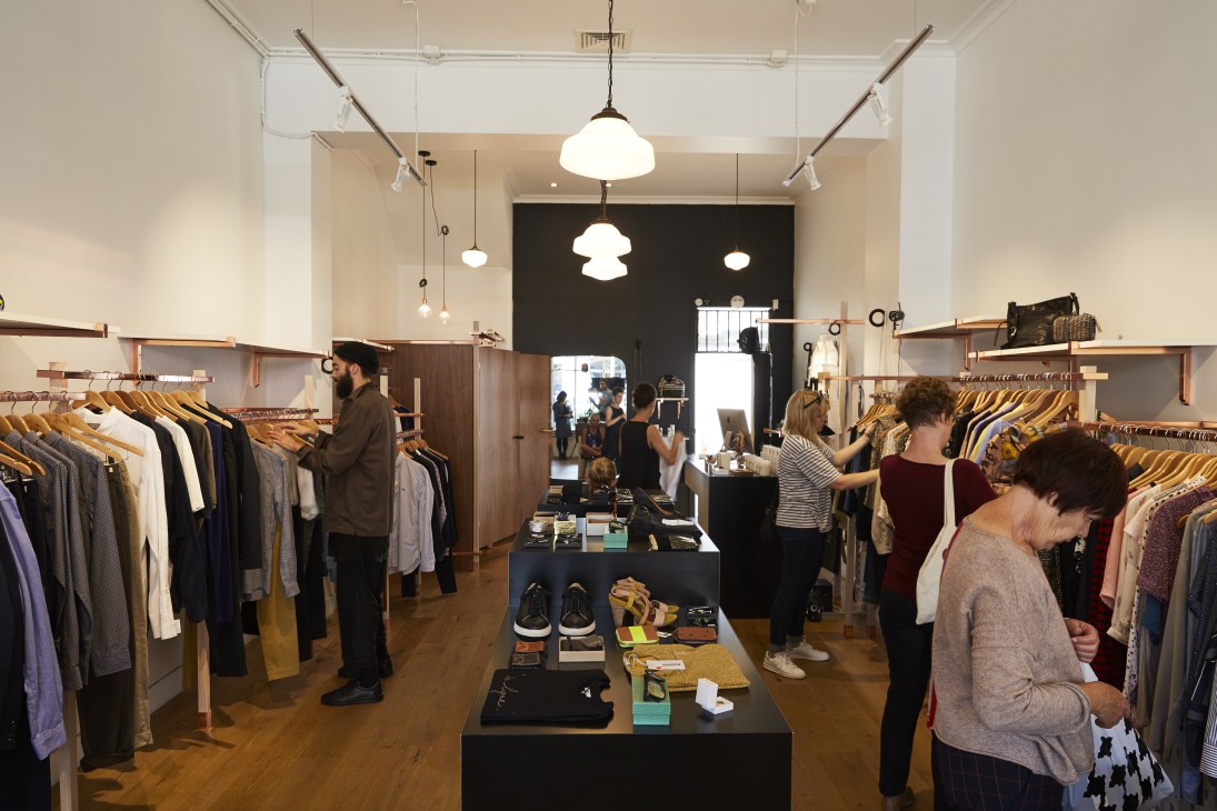 Interior of The Standard Store showing clothing racks, pendant lights, and customers shopping for apparel.