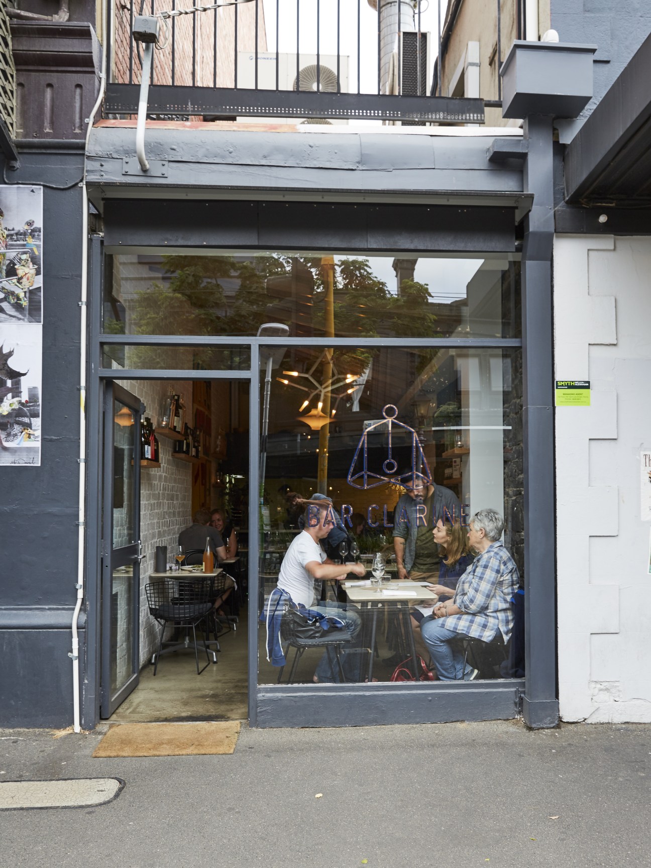 Bar Clarine storefront on Gertrude Street with customers dining at tables visible through large windows.