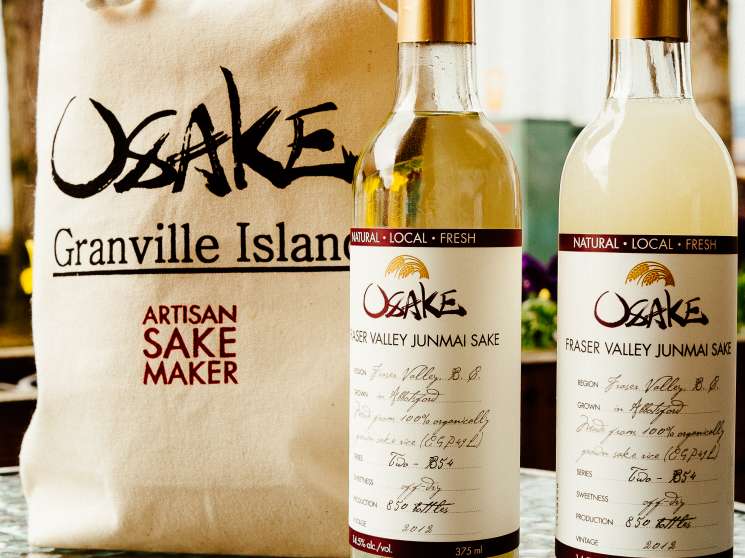 Two bottles of Osake Fraser Valley Junmai sake next to a canvas Granville Island tote bag from Artisan Sake Maker.