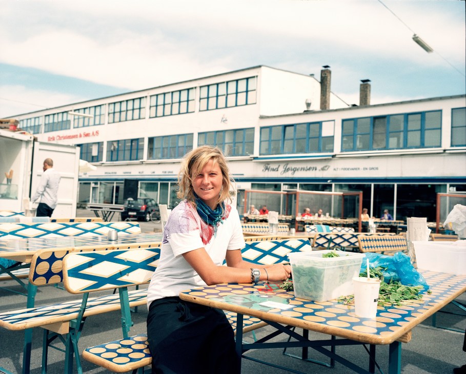 Julie Koch Fahler seated at a blue and white patterned outdoor table at Karriere café and bar in Copenhagen.