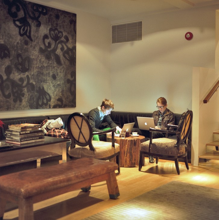 Two people working on laptops in the modern lobby lounge of 101 Hotel in Reykjavik.