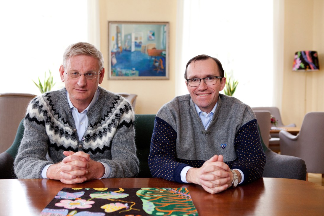 Swedish Foreign Minister Carl Bildt and Norwegian Foreign Minister Espen Barth Eide sit at a table wearing patterned knitwear.