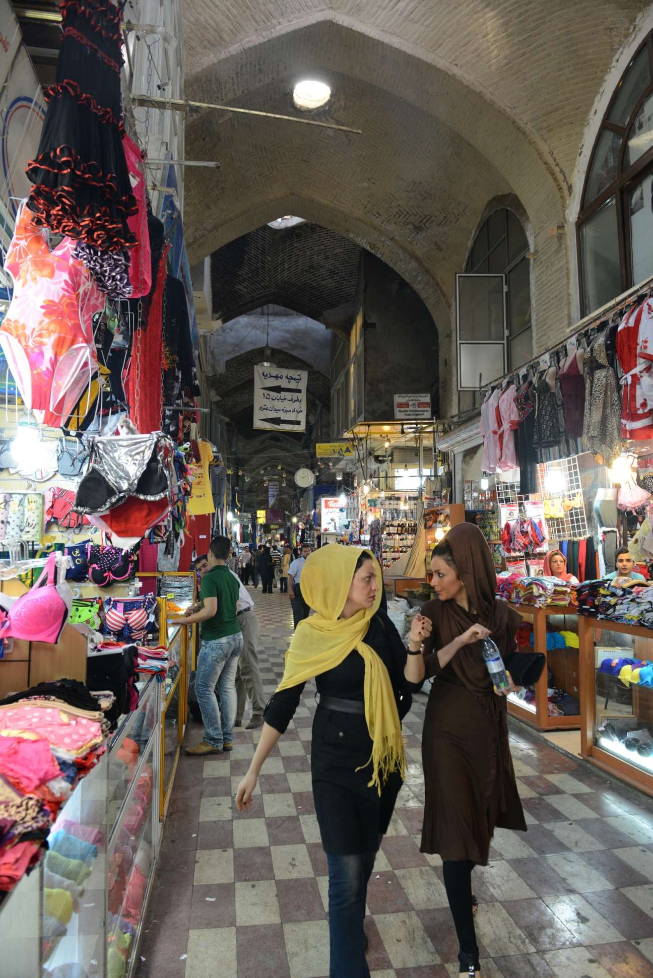 Two women walk past colorful underwear displayed in the Grand Bazaar in Tehran.