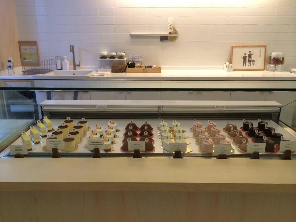 Display case of colorful Japanese cakes and desserts at Kki cake shop in Singapore.