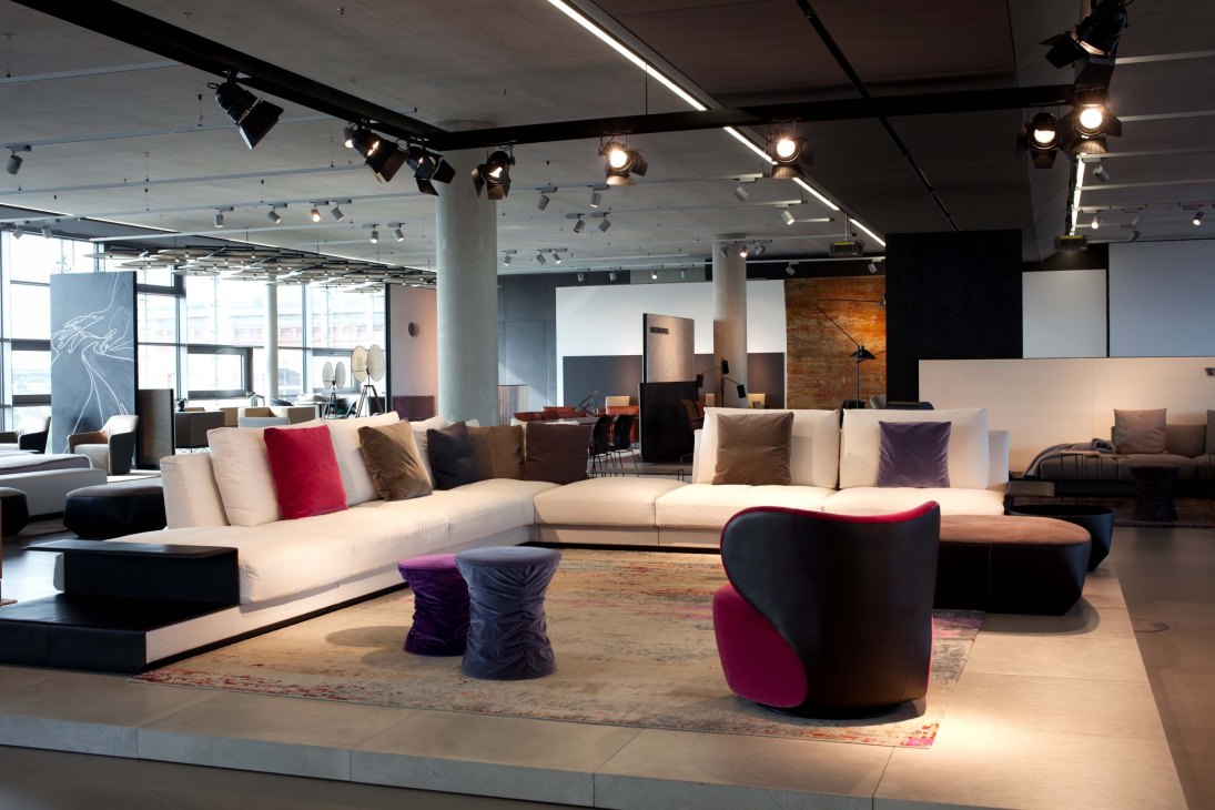 Walter Knoll furniture showroom displaying modern sofas and seating with cushions in neutral and jewel tones.