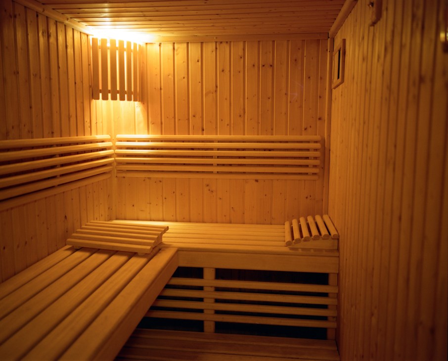 Interior of a wooden sauna with built-in benches and warm lighting at Nibork retreat.
