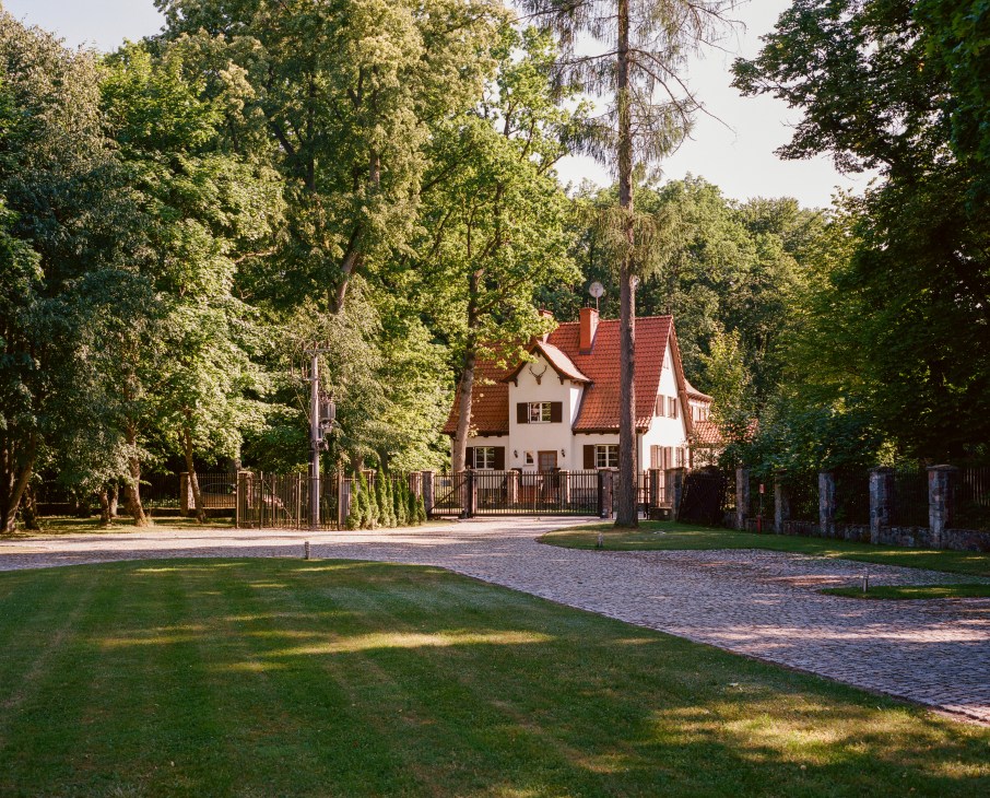 Nibork retreat main building with red-tiled roof surrounded by mature trees and manicured grounds.