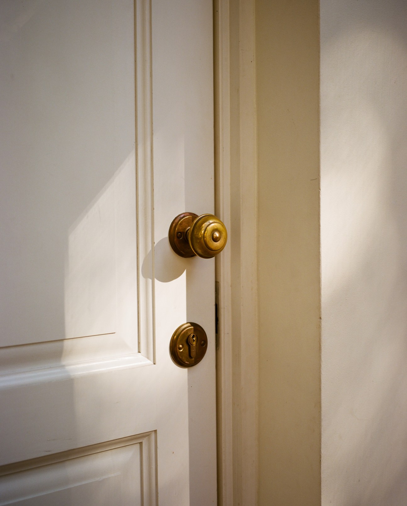 Brass doorknob and lock fixture on a white wooden door at Nibork retreat.
