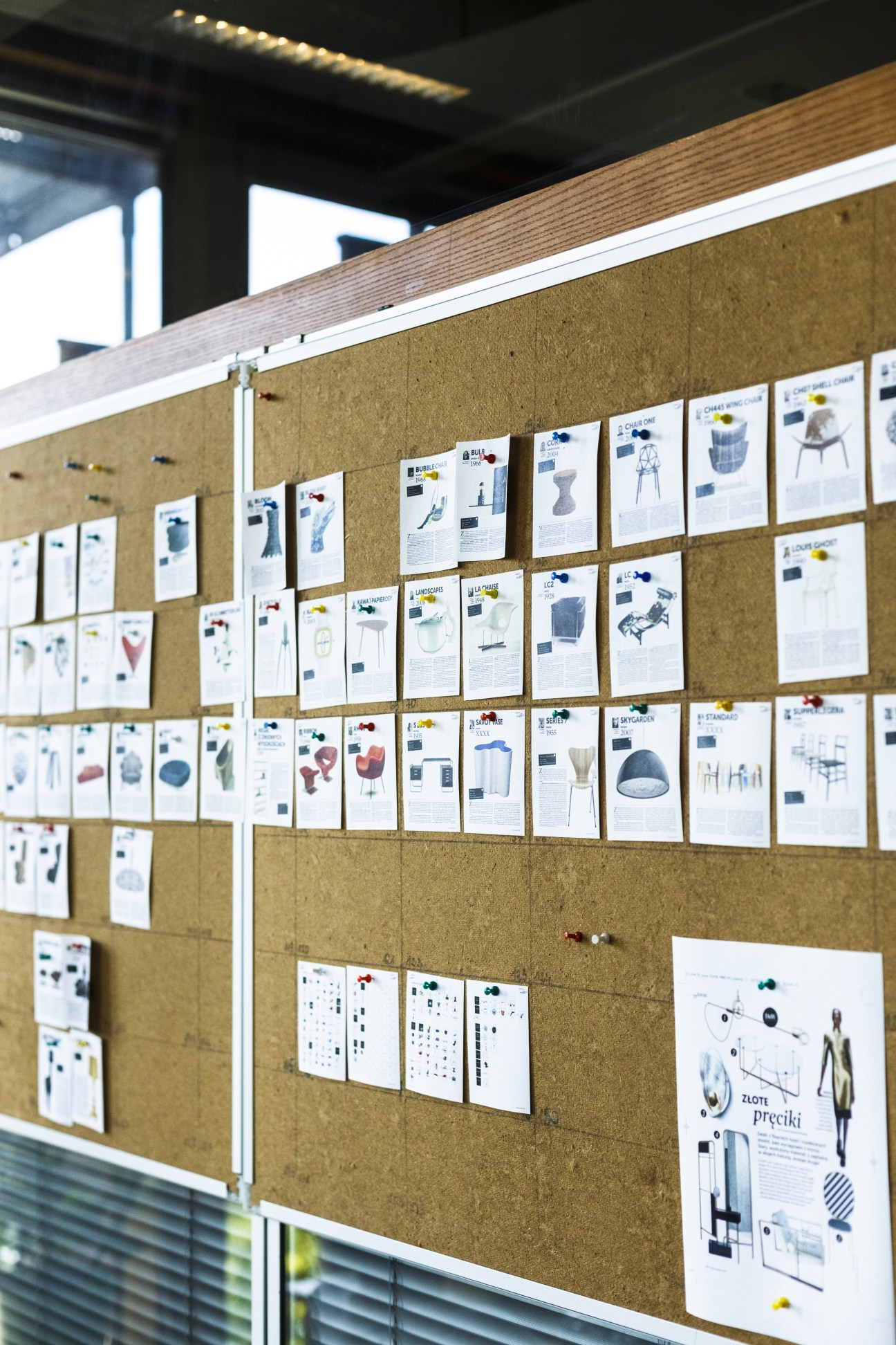 Design supplement pages pinned to a cork board in the Gazeta Wyborcza editorial office.