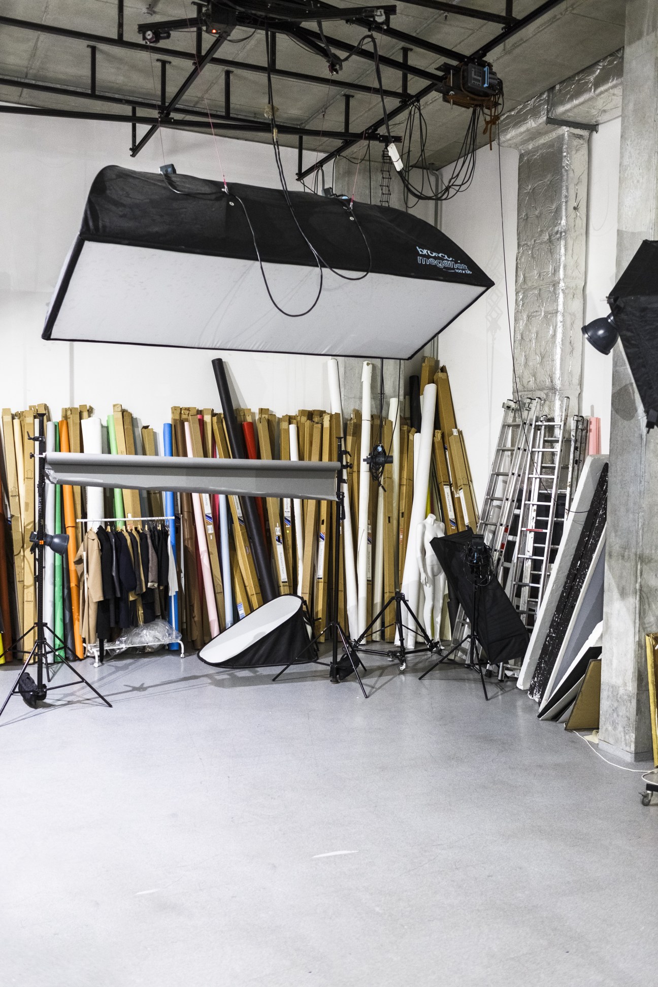 Professional photo studio in basement with lighting equipment, backdrops, and photography materials.