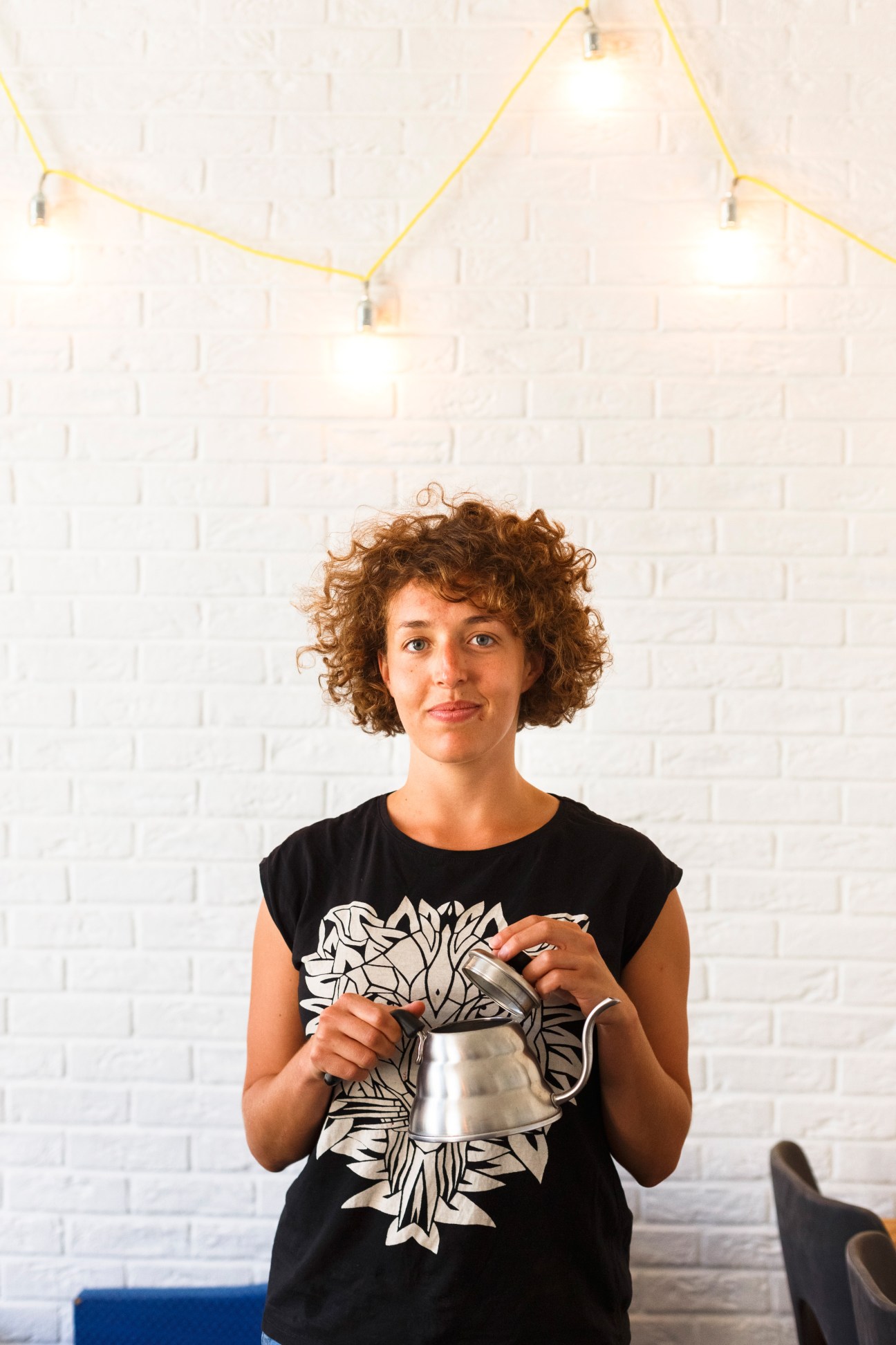 Barista Marta Majewska holds a metal coffee pitcher at Kurhaus café in Gdansk.