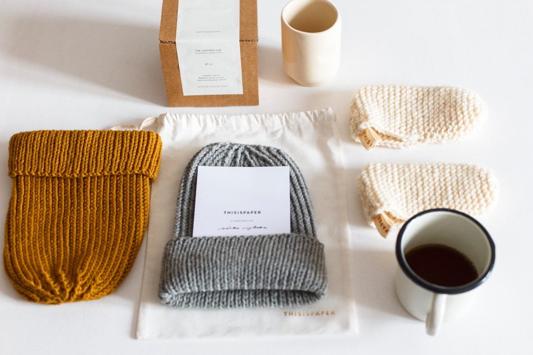 Thisispaper products including knitted pouches, mugs, and packaged items arranged on a white surface.