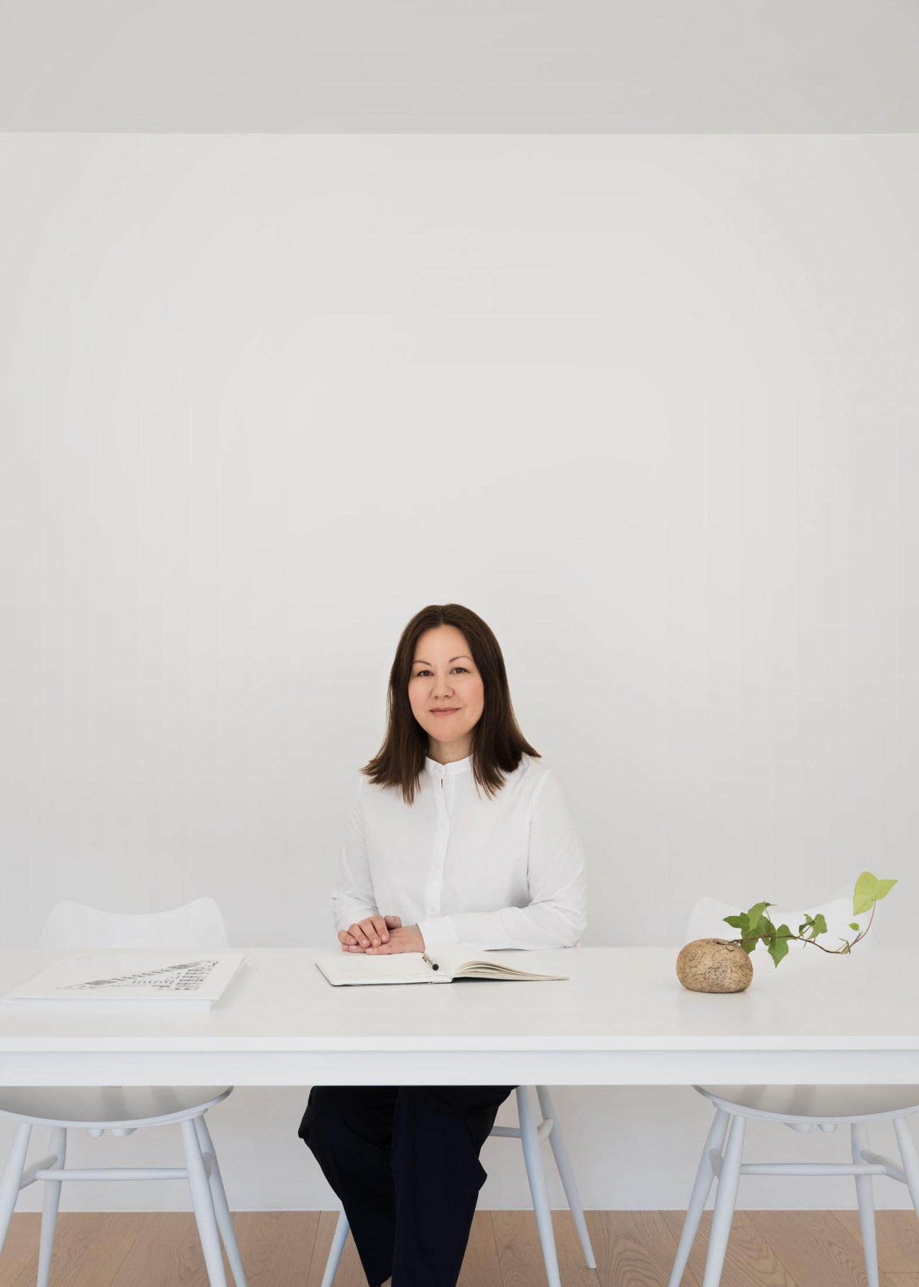 Marie Honda, Cos's managing director, seated at a white desk in a minimalist office setting.