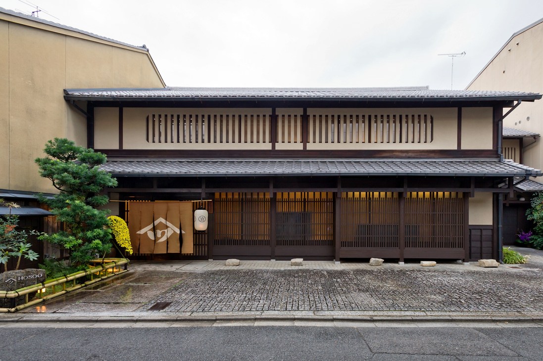 Historic Japanese building with wooden lattice windows and traditional architecture housing the Hosoo showroom in Kyoto.