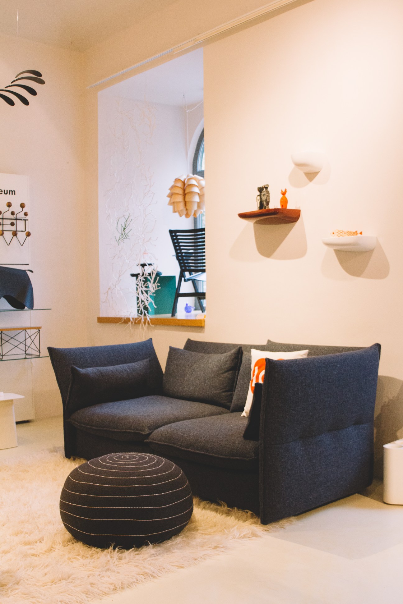 Contemporary furniture showroom display with dark sofa, wall shelves, and geometric décor in Kubus design shop.