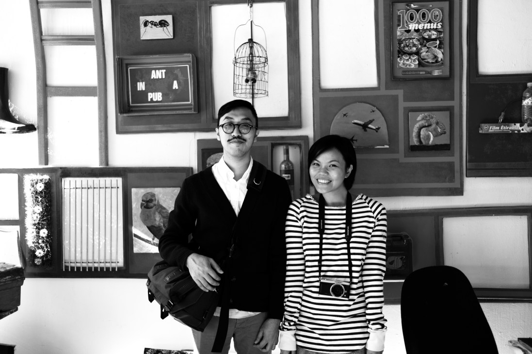 Amber Fu, managing director of Readymade magazine, poses with a colleague in front of an art-filled wall display in Hong Kong.