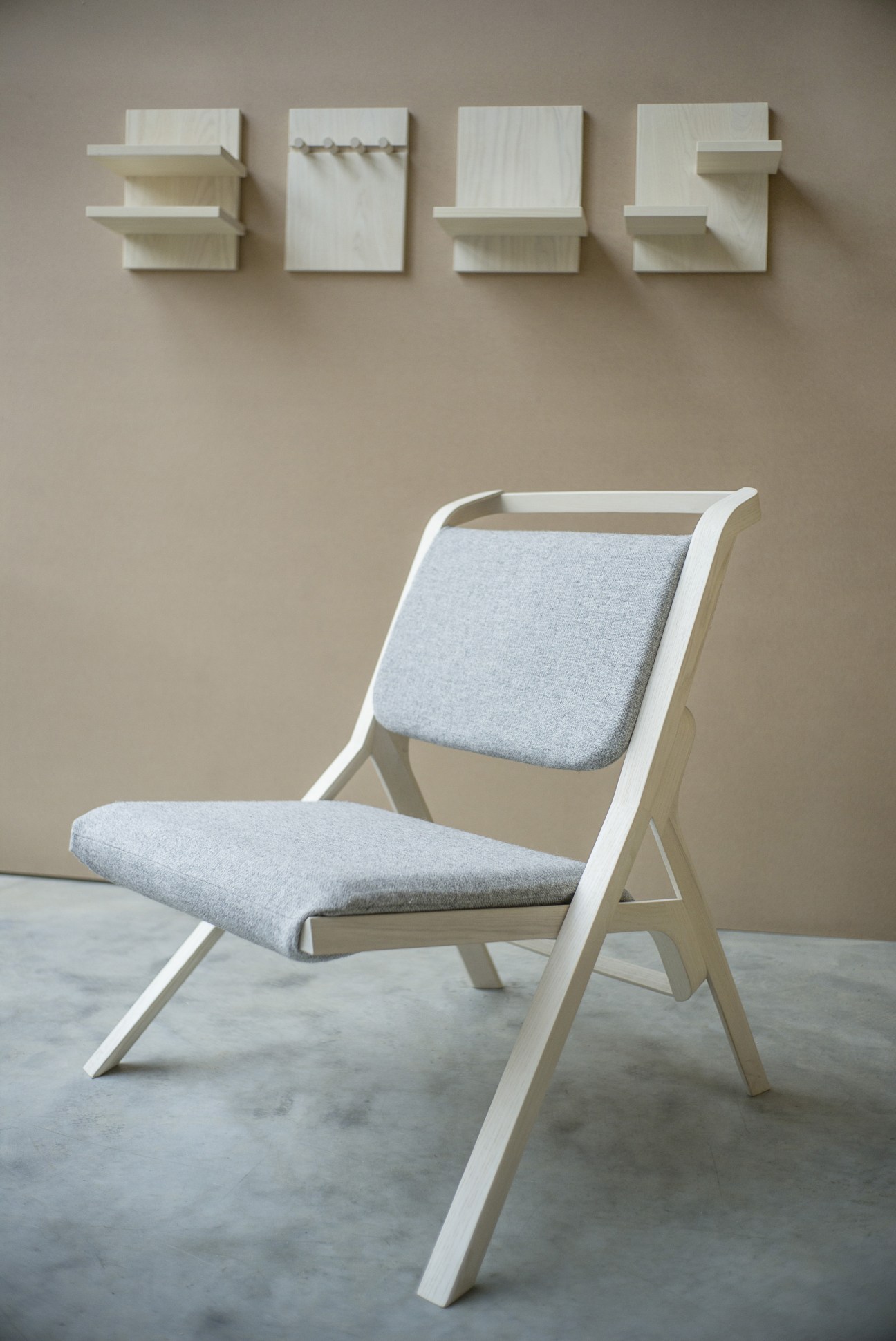 White wooden frame chair with grey upholstered seat and back, displayed with matching wall shelves above.