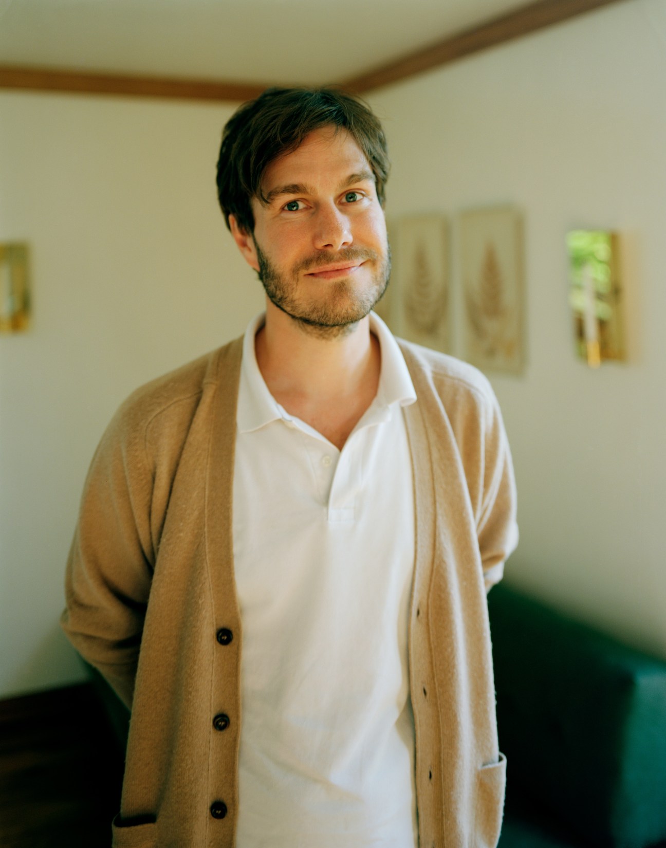 Portrait of Erik Persson, architect and one-fifth of General Architecture, wearing a tan cardigan over a white shirt.